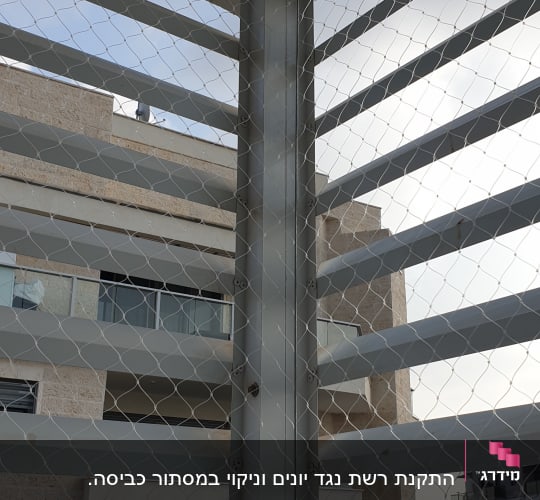 רשת מתכת מותקנת על מבנה למניעת כניסת יונים